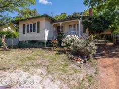  38 Lobelia Avenue Wundowie WA 6560 $150,000 Exhibiting an honest charm with its high ceilings and well-proportioned rooms this 1950 Wundowie original, although faded and in need of TLC, is an excellent example of unfulfilled potential. Occupying an elevated position on a 1012 sqm lot with a large, shady backyard, the 2 bedroom, 1 bathroom home is ready and waiting for someone to appreciate and uncover its allure. • 	 2 bedrooms 1 bathroom • 	 1950-built fibro and tile • 	 Renovators’ delight • 	 OP family/kitchen/meals • 	 High ceilings orig windows • 	 Activity/studio/sleepout • 	 Screened rear verandah • 	 Lge shady north face yard • 	 Elevated 1012 sqm block • 	 Walk town, school, pool Roses and lavender surround the front steps of this original Wundowie cottage. The fibro and tile home sits on an elevated lot and boasts a front porch with views to nearby bushland and across to a distant ridge. An open plan family room, kitchen and meals area offers the first glimpse of the potential of high ceilings and original windows. The carpeted family room enjoys views to the south and features an ornamental brick fireplace. The kitchen/meals area is large enough to accommodate a table and fitted with a U-shaped bench and freestanding oven. A reverse cycle air conditioner in the family room provides year-round climate control. Adjoining the kitchen is an additional living space with the potential of forming part of a larger, renovated kitchen. With access to the screened porch and backyard, this good-sized room could also be styled as a study or activity space. The well-proportioned main bedroom sits at the front of the home with reverse cycle air conditioner, the room has  windows to the south and is shaded by a tall pepper tree. Both bedrooms are carpeted and benefit from high ceilings. A family bathroom with over-tub shower and vanity and a separate W.C. are arranged off the walk-through laundry. A brick-paved verandah edged with raised garden beds leads from the screened porch to the spacious backyard where a garden shed, and carport provide handy storage space –  a drive-through carport sits at one side of the home. The country-style verandah looks out to established fruit trees and lush grape vine. Wundowie is a well-serviced country town with the infrastructure needed for a self-supporting community, including a police station, medical centre, ambulance station, fire brigade, community centre, library, post office, daycare, fantastic sporting facilities, public swimming pool and more.    There is no denying that hard work is required to make this faded rose bloom again, but sharp pricing and a great position make this a tempting prospect. To arrange an inspection of this property and experience the real difference in real estate call Mr Real – Nigel Williams – 0417 988 680. 