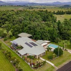  10 Marco Cl Pin Gin Hill QLD 4860 $950,000 - 3 distinct dwellings designed by a master builder - Over 10 acres - Infinity pool - Water tank of 62,000 litres - Dam and creek - Vegetable garden - Dual entrance - 5KW solar system - Generator fallback - Vast rainforest estate - Only minutes from town - Peaceful and private - Magnificent views - Riding lawnmower - Gym - 1 hour from international and domestic airports Property Specifics This one-of-a-kind property was lovingly created by a master builder who was way ahead of his time. Being on the cutting edge of natural health and sustainable living It was designed as a luxurious survival block for when the shop shelves ran out of supplies. 10.5 acres, almost an entire valley, with golf course-style greens and about 4 acres of old growth rain forest up the hillsides and around the creek. Yes, you will have your own valley with a dam for swimming and/or farming. Because the rich volcanic soil lacks clay, the dam was built with a heavy-duty liner and remains full all year. She is 18 feet deep, straight off the dam wall, and has a syphoning system with a one-way valve installed so that it syphons from the bottom of the dam, flowing under rather than over the spillway. fruit trees that have been established, including rare exotic fruits. Buildings The main house is constructed of brick and tile, with cyclone rods anchoring it to the hillside. It has been through two Category 5 cyclones with little damage and has a shelter for cyclones. There are three bedrooms, all with built-in robes, as well as an office. Rest rooms are available both upstairs and downstairs. A stunning Tasman oak kitchen and open-plan living room bring the entire family together. sunken lounge with curved reclining loungers. The house was built for the tropics and is completely air-conditioned with split systems. If you'd rather have a breeze than air conditioning, it also has a cost-effective central exhaust fan that lets the breeze come in through any window. The master bedroom opens onto the veranda, which connects to the outdoor BBQ area and the stunning infinity pool. During the day, the views from here are breathtaking. And floating in the pool at night, when the water is spilling over the illuminated waterfall, gazing up at a billion stars is like, "Wow." Just wow! The lockable 8-car garage is also a cyclone shelter, has its own bathroom and toilet, and houses a monstrous workshop with 3-phase power and a gymnasium with views of the vegetable garden. A very spacious, fully self-contained single-bedroom unit is located at the far end of the main house. Fully air-conditioned and tiled throughout, with rainforest views. There is a new gas stove, a built-in laundry room, and a private deck. The dual entrance allows for complete privacy and is wheelchair accessible. boat or machinery shed with a high roof. It easily accommodates two trailer sailors or tip trucks. Underneath is a mind-boggling 62,000-liter concrete water tank. The entire property can be easily converted from rainwater to city water. Finally, there is a separate, secluded two-bedroom house in the valley with a view of the dam. A separate driveway provides access. It has a two-car garage and a garden shed. ceiling fans and louvres throughout to capture the breeze while repelling rain. The possibilities for this location are limitless; let your imagination run wild. As you might expect, no expense was spared during the 30+ years it took to bring this creation to life. The master who made it has passed away, and it is too large for his family. Because much of the furniture was handcrafted and designed specifically for the house, it will be sold fully furnished. 