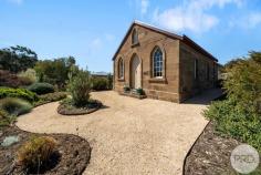  37 Briggs Road Old Beach TAS 7017 $730,000 - $780,000 Nestled at the edge of rural properties, within a 30-minute journey from Hobart's CBD, a captivating secret is poised to be discovered - a sandstone church that has withstood the test of time since the 1800s. This remarkable property is now seeking a new owner, a guardian of history, and a tender of the land. Its story is one of meticulous preservation and an invitation to a life steeped in heritage. As you approach the property, it's the original church doors, sandstone exterior and church windows that first capture your attention. The stone exterior, weathered by centuries, exudes an air of timelessness. Approaching the entrance along a tree lined driveway, you are greeted by a crushed gravel pathway that winds around part of the graveyard and beautifully designed native gardens. Upon crossing the threshold, you are transported to a bygone era. The lower level of the church is a harmonious blend of old-world charm and contemporary convenience. Polished concrete flooring in the rustic, country-style kitchen at one end meets the spacious, timber floored lounge at the other. The homely kitchen feature gas cooktops, wooden benches and double French doors opening onto a covered outdoor area-a place for alfresco gatherings under the protection of a high roof. Here, friends and family come together, creating cherished memories amidst the enchanting surroundings. Also on the lower level you discover the main bathroom complete with bath, a second bedroom with built in wardrobes (currently being used as a reading/writing room), the laundry and an adaptable walkthrough space, poised to serve as a home office where inspiration flows amidst the whispers of time. As you follow the hallway to the lounge through one of the original church doors, featuring a stained-glass window depicting St George slaying the dragon, you are drawn to the west facing windows that capture the golden rays of the afternoon sun. Here, the cathedral ceilings soar high above, a testament to the grandeur of the past. The lounge room proudly displays the church's original features, a tapestry of history within its very walls. A graceful staircase leads to a mezzanine level, where the main bedroom awaits. Elevated above, it offers a private retreat, a place to rest, dream, and reflect. Stay warm and cosy, even in the coldest winter months, with thermostat controlled hydronic heating featured throughout the entire church. Stepping outside and wandering through the gardens, you'll find a serene haven of meandering paths that wind through a rich tapestry of foliage, fauna, and native plants. This generous 4000sqm allotment invites you to embrace the beauty of your surroundings and reconnect with nature without leaving home. At the rear of the property, a separate studio stands as a self-contained haven. It's a modernized space with a comfortable living area, a well-appointed kitchen, stylish bathroom with large walk-in shower, a spacious bedroom and a gravel fire-pit (or a hot tub?) area out the back. Consider the possibilities: a private retreat, a guest house, or even an Airbnb opportunity (subject to council approval). This is more than just a house; it's an invitation to live a lifestyle enriched by history, serenity, and purpose. Whether you seek a haven of tranquility, a unique home, or a distinctive business venture, this property offers it all. Embrace the divine blend of old and new and become the guardian of this unique piece of history. To step into this extraordinary story, arrange a private viewing of this exceptional property today. 