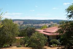 77 Bailey Heights Balingup WA 6253      HEAVENLY HEIGHTS This beautiful 4 bedroom, 5 bathroom homestead is nestled on 5 acres with stunning breathtaking views of the village of Balingup. The homestead would be ideal as either a family residence or a boutique style Bed and Breakfast. Finished with attention to detail, the spacious homestead has many classic character features. Jarrah floorboards throughout the living areas and the ornate ceiling roses create a timeless ambience. Timber French doors lead out onto wrap-around verandahs from which to view the surrounding countryside and rolling hills. A wide hallway leads down to the open-plan lounge and dining area. This living area has magnificent views of the surrounding countryside, and is heated in winter by a cosy slow combustion stove. It also has reverse-cycle air conditioning. The living areas and verandahs are an ideal place from which to view the winter mists slowly lift from the hillsides and valleys, or enjoy the stunning sunsets. The living area can be separated into two spacious sections if preferred. Large bi-fold doors can be closed to form a private (hosts) retreat. The kitchen is located in this section, and is well planned, with a free-standing substantial jarrah workbench, and generous cupboard and storage space. The kitchen also has a six burner 900 Smeg gas stove top with an electric oven, and dishwasher . The master bedroom is also located in this section of the homestead. All four bedrooms are spacious with French doors opening on to verandahs overlooking the peaceful front gardens. All of the bedrooms have ensuites, reverse-cycle air-conditioning and ceiling fans. Another separate bathroom has a shower, vanity and toilet. An additional large storage or linen room is accessed from the hallway. This delightful property even has the ideal 'his and hers' 'shed'! For every lady who has ever wanted her own shed, this would have to be one of the best! It is currently used as a studio/ massage room and has reverse-cycle air-conditioning and beautiful views of the valley and hills. The other is a double garage/shed with roller doors, concrete slab and power. The property also has a large Jadan six-seater spa and a garden gazebo to relax and enjoy the views. Terraced limestone walled gardens surround the home. The property also has a mature oak tree, and other deciduous trees, as well as established almond, fig, citrus, stone fruit and olive trees. Two 100,000L rainwater tanks provide water for the homestead. For more information, please contact either John or Sue on 97641089