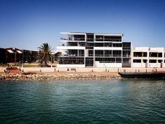  5/285 Foreshore Drive Geraldton WA 6530 MOORINGS WATERFRONT APARTMENT-GERALDTON http://youtu.be/94cPv99Lzfg  This is your opportunity to secure one of the larger and better positioned apartments on the second level of Geraldton's Iconic luxurious waterfront apartment development, The Moorings. This 3 bedroom + study, 2 bathroom residence boasts 164m2 of living area plus a 67m2 outdoor entertaining balcony that offers stunning views of the ever changing colours and activity of the Indian Ocean. The unique design philosophy ensures that size, layout and function delivers a residential lifestyle that exceeds expectations. The interior design achieves the sought after combination of aesthetics and functionality. A sophisticated fusion of colour, texture, the finest materials and appliances delivers stylish and contemporary spaces. High ceilings and the use of floor-to-ceiling glass combine to integrate indoor and outdoor living areas, creating a tangible sense of space, whilst also maintaining maximum privacy. The fully equipped and functional chef's kitchen, complete with Miele oven, gas cook-top, range hood, microwave and dishwasher boasts Caesarstone benches and the design and layout takes advantage of the views of the Marina. The sleek and stylish bathrooms feature designer tapware, caesarstone vanities and semi-frameless glass shower screens. Elegantly styled and generously sized showers, with a high capacity central hot water system economically ensuring your hot water never runs out. The master bedroom lets you wake up to the amazing ocean views and its own private screened balcony. Final touches include Foxtel Digital and ADSL broadband ready. Internal climate is controlled through fully ducted reverse cycle air conditioning, (with the condenser on the roof and not on your balcony) and the use of laminated, solar control glazing. Feature building design elements cleverly reduce the influence of wind and rain on balcony entertaining areas. Your residence also comes with an individual 7m2 storeroom and two secure undercover parking areas on the ground floor. The Moorings has all entrances secured via electronic access control technology including video intercom, security-keyed lift lobby doors and lifts and gated secure parking. Viewing by appointment with Lara Sadowski 0407160175  Balcony Air Conditioning Built-In Wardrobes Close To Schools Close To Shops Close To Transport Secure Parking Pool 