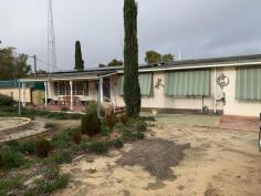  7 Gamble St Wyalkatchem WA 6485 $200,000 Timber framed, brick clad with an aluminium roof on a corner block of 1033m2. This house was built in 1969 and is in excellent condition. There are 3 bedrooms all of which are generous in size, all are carpeted, have air con and ceiling fans with the main bedroom having a built in robe. The bathroom has recently had major renovations done to it to allow for wheel chair access, every thing has been replaced and an extra WC having been added. A large linen cupboard is located in the hallway. Kitchen is large and very well appointed, lots of cupboard space,  a large pantry cupboard, electric wall oven and hot plate, vinyl floor covering, split air cond services the kitchen/dining room. Dining room is large with a sliding door opening  out onto the entertaining area and easy access to the large lounge room. Lounge room is carpeted with a large window to allow plenty for sunlight to fill the room plus ceiling fan, a gas bayonet is located in the passage for extra gas heating if required. A reading room/office which is also carpeted is located off the laundry.   A well equipped laundry with an additional shower and toilet and a tiled floor. HWS is electric, plus the house has a 20 panel solar PVA system to keep the power bills down. The front of the house has a veranda across part of the house, a rear veranda across the length of the rear of the house, the garage has a cement floor with power connected, a carport in front of the garage that has room for 2 vehicles. The low maintenance garden is all reticulated, a number of fruit trees, the property is well fenced in super six fencing, side access, 3 bird aviaries, and a large plastic rain water tank. This property is clean and tidy and has been well maintained over many years and is ready to move into with no additional money to be spent on it. Located close to the high school and within easy walking distance to the Doctor Hospital and aged care facilities. Viewing is by appointment only, to make an appointment please contact Eric on 0429886107 to arrange a time, you will not be disappointed with this property… 
