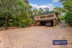  3 Carawatha Rd Parkerville WA 6081 $699,000 Positioned at the top of a sweeping paved driveway, nestled amongst parks and a reserve where dappled sunlight is filtered through ancient trees and wildflowers weave a tapestry of nature’s beauty, this Parkerville home is a symphony of threes. Three interconnected living areas, three bedrooms and three outdoor living and entertaining zones. • 	 3 beds 1 bath 2 WC • 	 1979-built brick & tile • 	 Formal lounge/dining • 	 OP kitchen/fam/meals • 	 Main bed semi ensuite • 	 3 outdoor living zoned • 	 Paved drive to carport • 	 Gate to Reserve • 	 1912 sqm elevated lot • 	 Walk to Parkerville Pub • 	 With its elevated position and natural setting, this Parkerville home has the air of a mountain chalet and will enchant the hearts of those who believe in the magic of threes. North-facing decks and a wide, sheltered patio provide ample space for alfresco living and entertaining; a gate in the rear fence offers direct access to Reserve, Yennerdin Park is at the end of the street, and a path leads through Brookside Park for a seven-minute walk to the Parkerville Pub. The home is bright and welcoming with a formal lounge and dining room looking across a deck to the north, a kitchen/meals/family room offering a sociable space for informal entertaining and living and a multi-purpose library/media room with lots of built-in storage and an east-facing window framing a painterly scene of eucalypts and grass trees. The kitchen boasts overhead and under-bench storage, a freestanding oven, a dishwasher and an integrated breakfast bar. Reverse cycle air conditioning provides summer cooling while a slow-combustion fire offers winter warmth and a place to gather and share stories and make memories with family and friends. Two junior bedrooms sit at the rear of the plan while the main bedroom – a generously proportioned room – sits at the front of the layout with fabulous north-facing views, a large built-in wardrobe and semi-ensuite access to the family bathroom. The fully fenced backyard has direct access to Reserve, the front yard is all about the views and peaceful bush setting of two large decked entertaining areas. The first extends from the front of the home and is partially sheltered under a gabled roof. The second is nestled towards the front of the lot at the end of a winding path. Surrounded by a Colorbond fence and bosting a light-strewn gazebo this large open space is a wonderful space for play and entertaining. With a quintessential Hills setting and easy access to the local school pub and nearby Mundaring, this House of Threes stands as a testament to harmony and balance. It is a place where dreams flourish and laughter echoes, creating a fairy tale haven for those lucky enough to step through its doors. To arrange an inspection of this property, call Ken Wiggins on 0403 012 950 